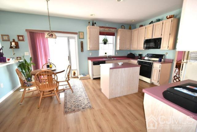 42 Timber Ridge Road North Brunswick, NJ 08902 - Photo 40 of 43 a kitchen with a table chairs microwave and cabinets