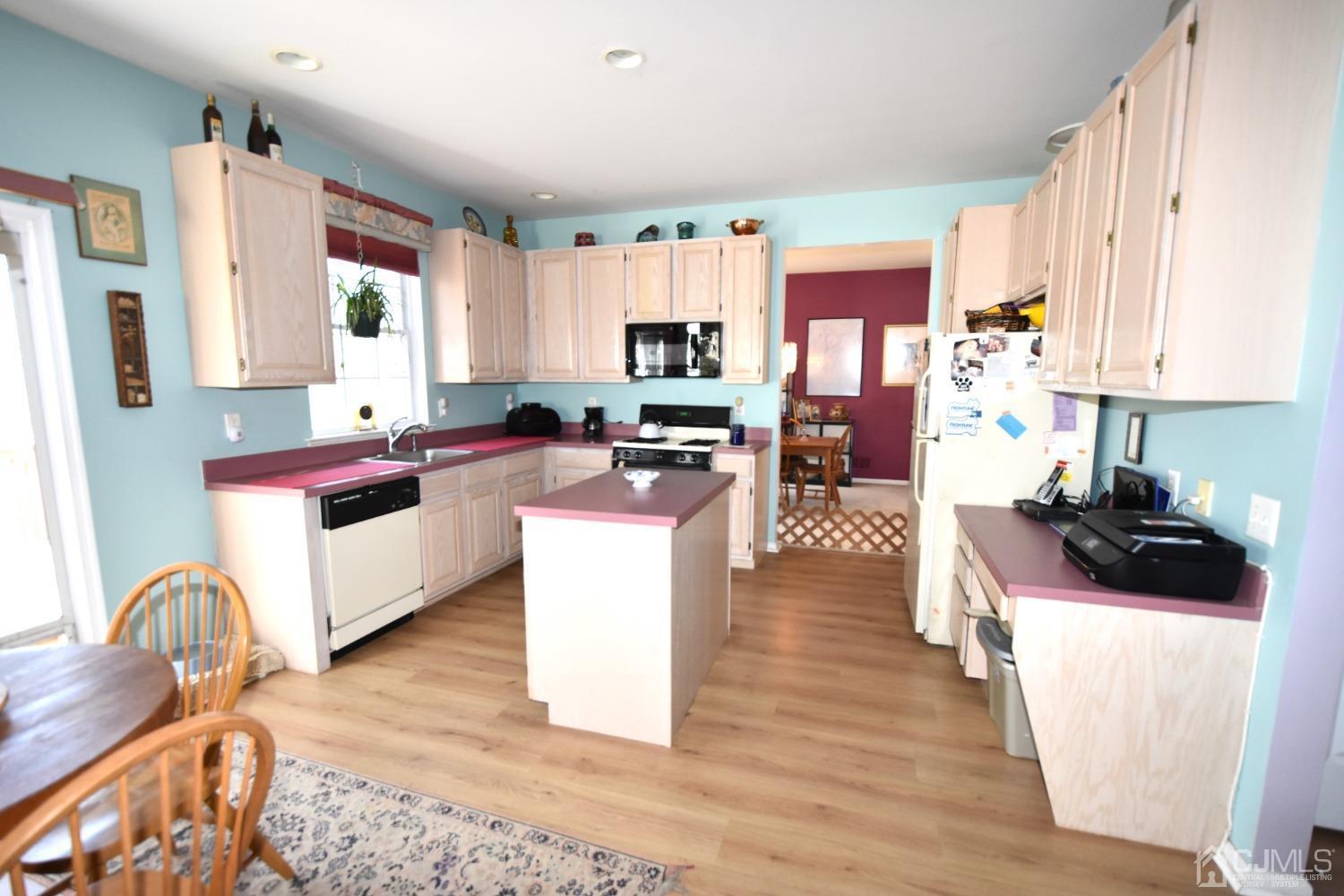 42 Timber Ridge Road North Brunswick, NJ 08902 - Photo 5 of 43 a kitchen with stainless steel appliances kitchen island granite countertop a stove a sink dishwasher and white cabinets with wooden floor
