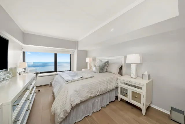 a bedroom with a bed and a large mirror on the dresser