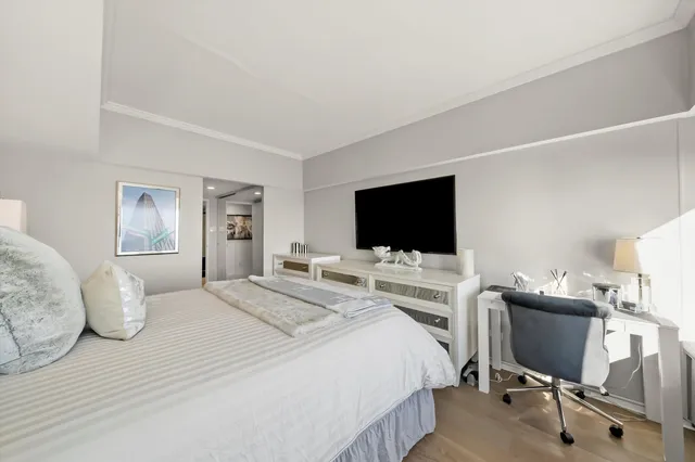 a bedroom with a bed a television and a large window