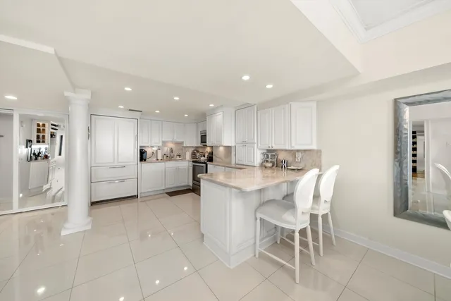 a kitchen with kitchen island white cabinets and stainless steel appliances