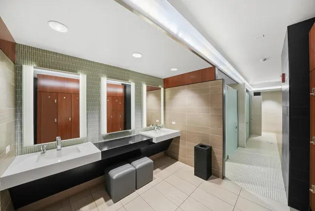 a bathroom with double vanity and a mirror