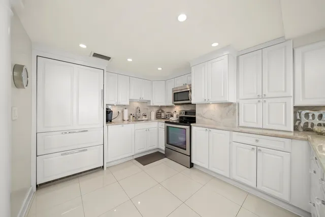 a kitchen with white cabinets and white appliances