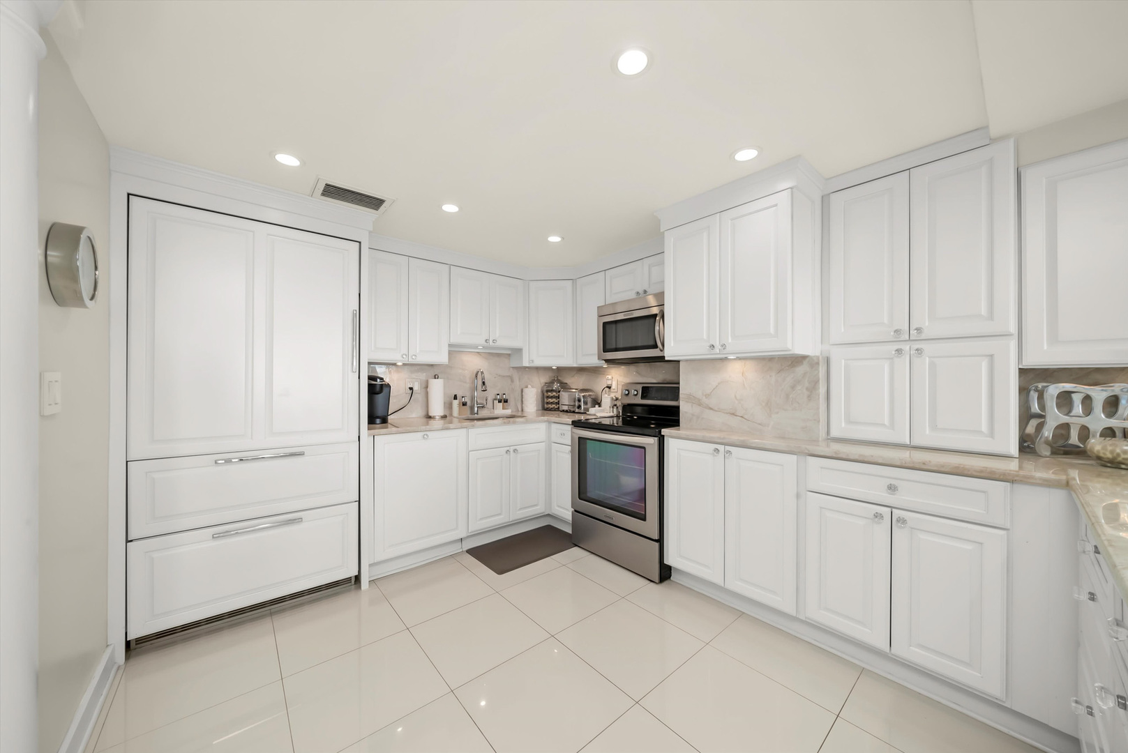 175 East Delaware Place, Unit 7107 Chicago, IL 60611 - Photo 4 of 42 a kitchen with white cabinets and white appliances