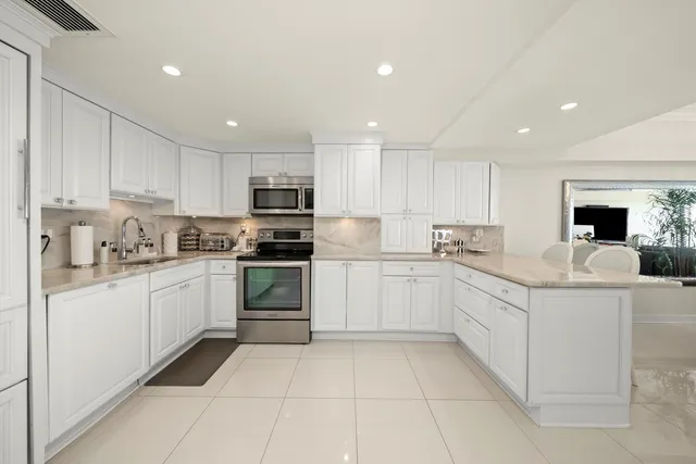 a kitchen with granite countertop cabinets and white stainless steel appliances