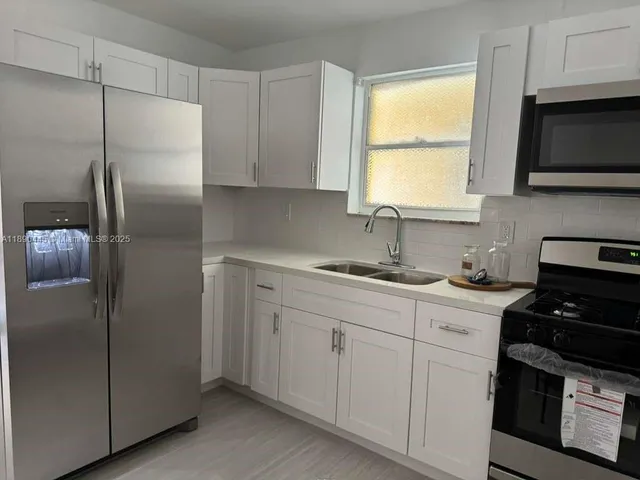 a kitchen with a sink appliances and cabinets