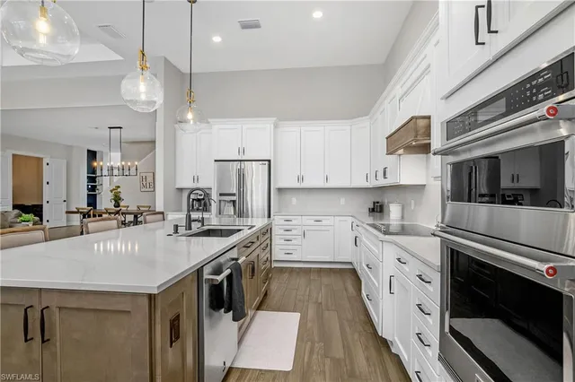 a kitchen with a stove a sink a refrigerator and cabinets