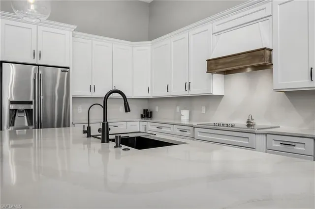 a kitchen with stainless steel appliances granite countertop a refrigerator and a stove top oven