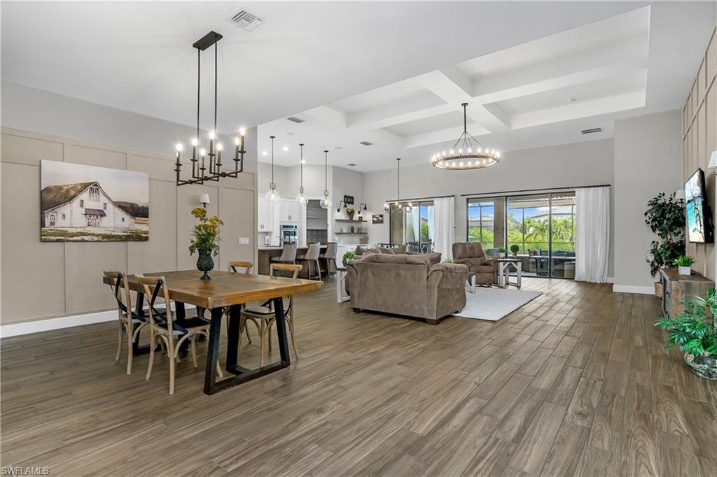 17570 Ashcomb Way Estero, FL 33928 - Photo 15 of 50 a living room with furniture dining table a chandelier a rug and a potted plant