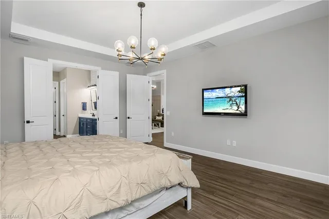 a spacious bedroom with a bed and a chandelier