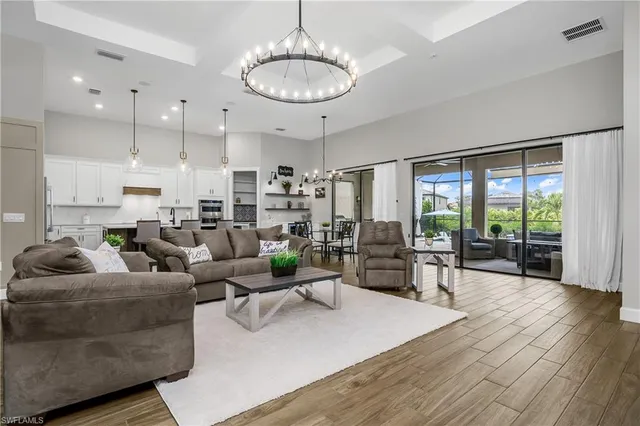 a living room with furniture kitchen and a large window