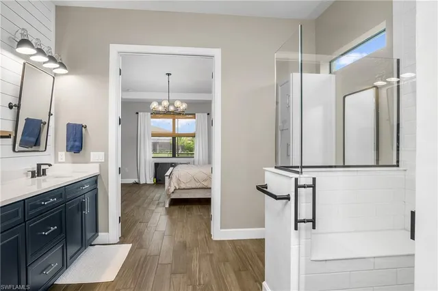 a en suite bathroom with a double vanity sink a mirror and shower