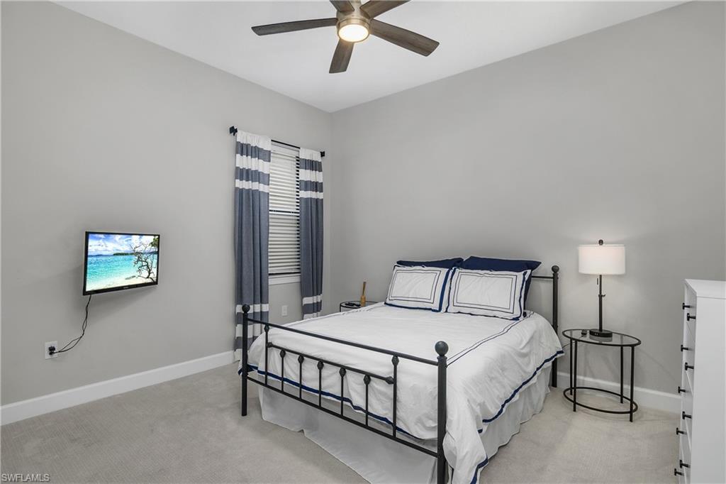 17570 Ashcomb Way Estero, FL 33928 - Photo 25 of 50 a bed room with a bed and a chandelier