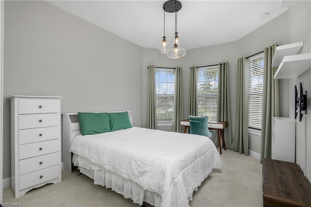 17570 Ashcomb Way Estero, FL 33928 - Photo 27 of 50 a bedroom with a large bed and a chandelier