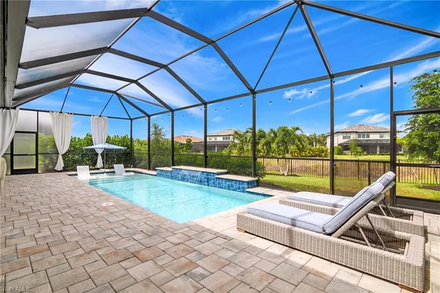 a view of a patio with couches table and chairs under an umbrella