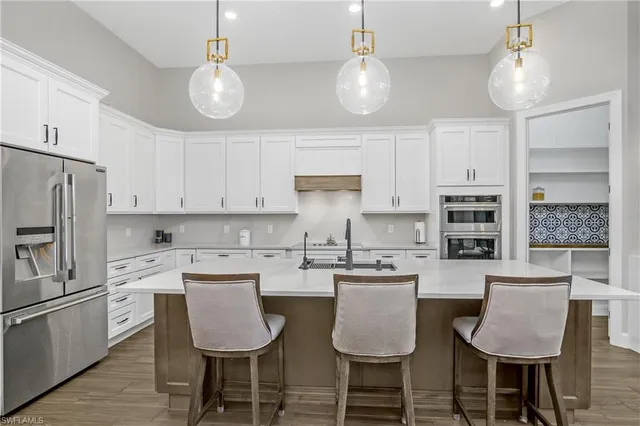 a kitchen with a dining table chairs sink and cabinets