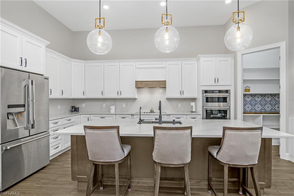 17570 Ashcomb Way Estero, FL 33928 - Photo 7 of 50 a kitchen with a dining table chairs sink and cabinets