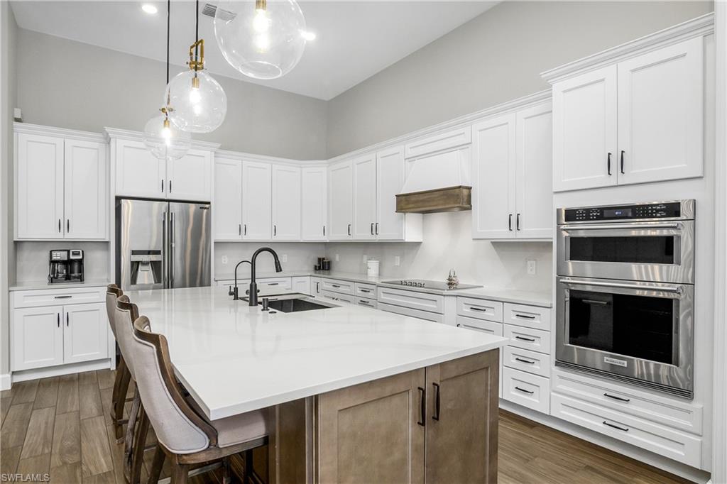 17570 Ashcomb Way Estero, FL 33928 - Photo 8 of 50 a kitchen with stainless steel appliances a stove a sink a stove a refrigerator cabinets a dining table and chairs