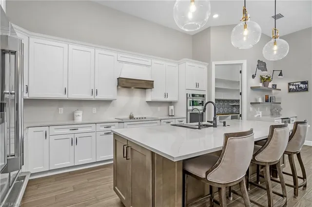 a kitchen with stainless steel appliances granite countertop a sink a stove and a refrigerator