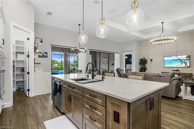 a kitchen with a stove a refrigerator a sink dishwasher and a dining table with wooden floor