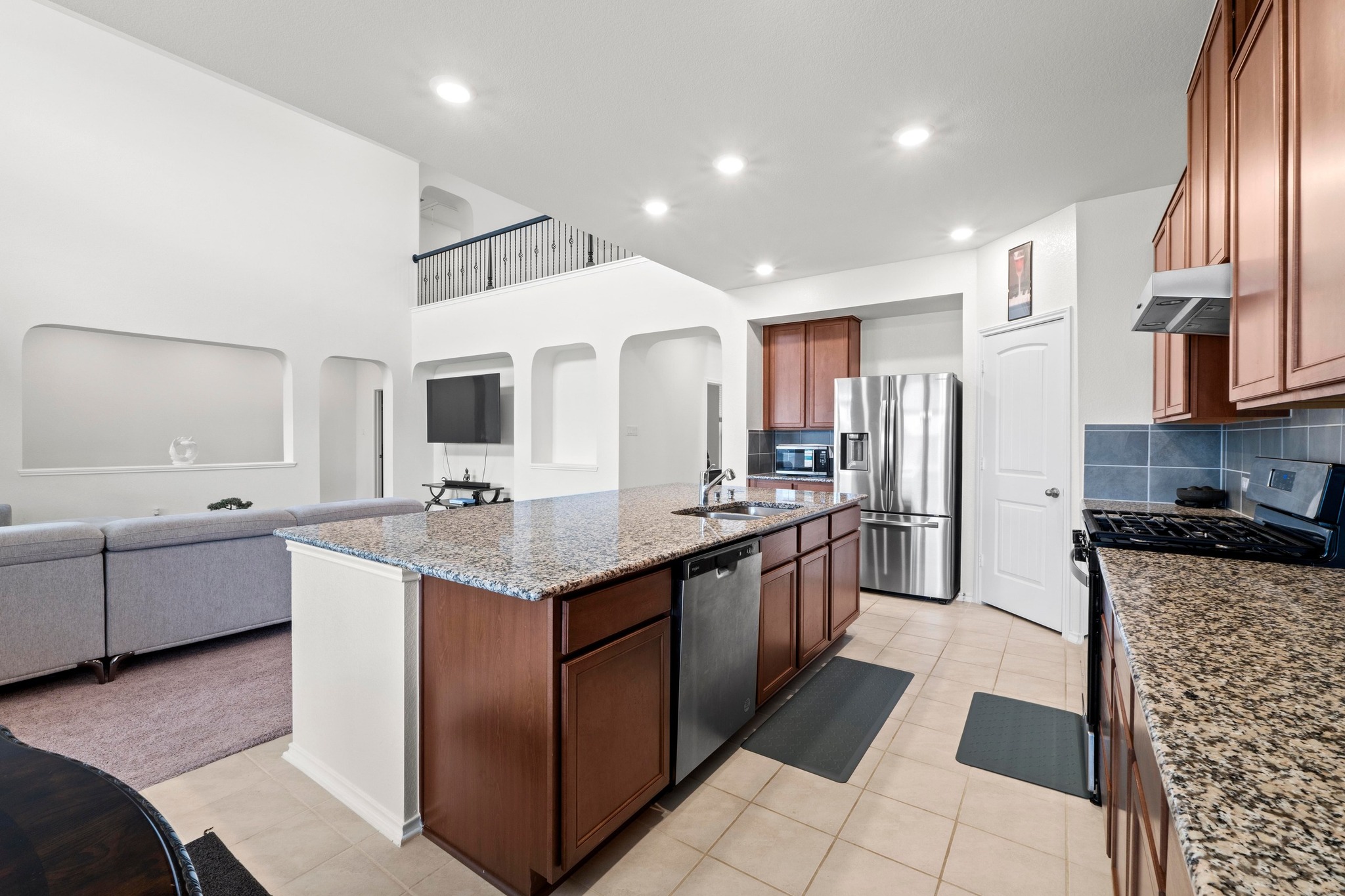 4729 San Rufo Drive Round Rock, TX 78665 - Photo 11 of 36 Spacious kitchen featuring an expansive center island with granite countertops, stainless steel appliances, wood cabinetry, and tile flooring