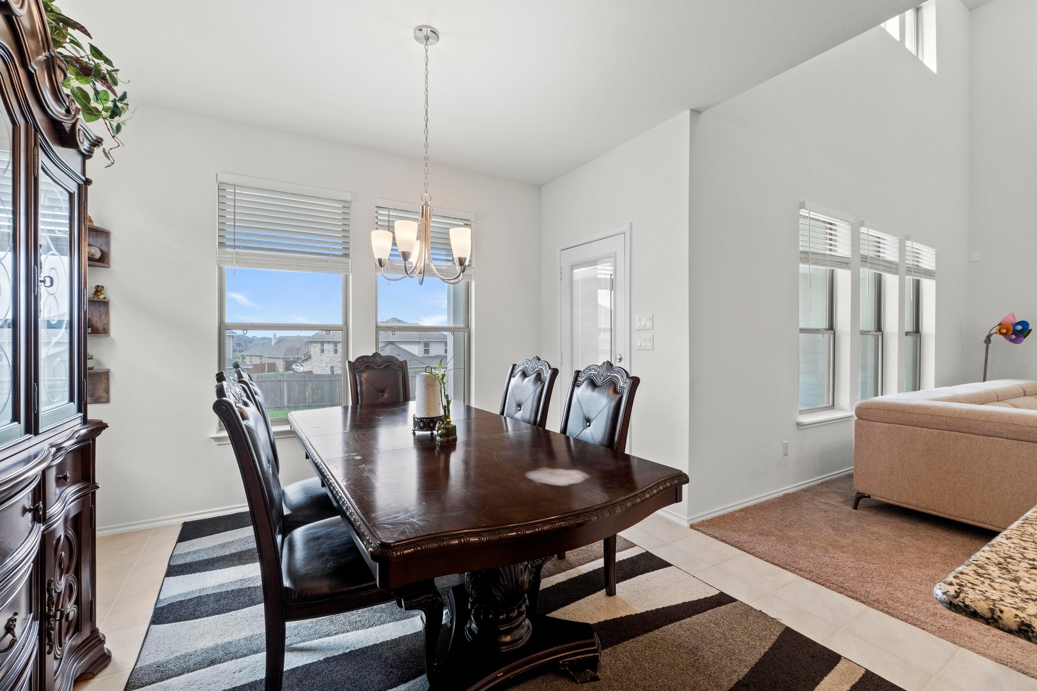 4729 San Rufo Drive Round Rock, TX 78665 - Photo 12 of 36 Bright dining area featuring a contemporary chandelier, multiple windows with natural light, and light-toned flooring