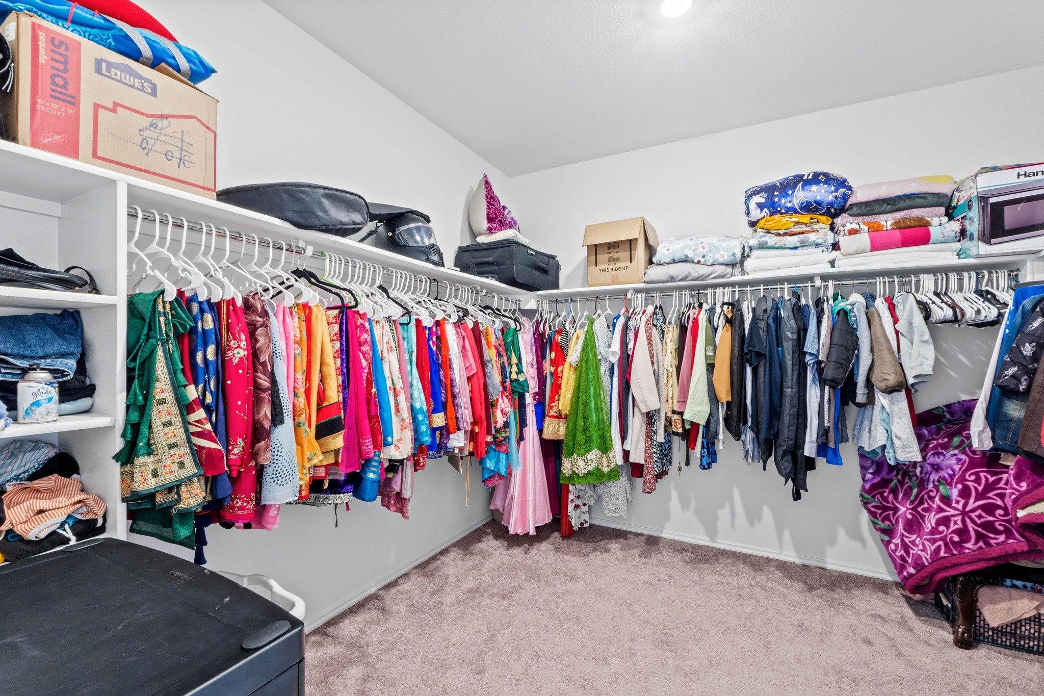 4729 San Rufo Drive Round Rock, TX 78665 - Photo 17 of 36 Spacious walk-in closet featuring white wall-mounted shelving, extensive hanging rods, and light-toned carpeting