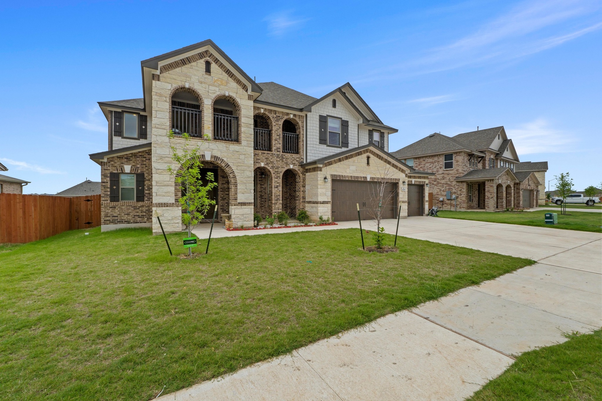 4729 San Rufo Drive Round Rock, TX 78665 - Photo 2 of 36 Two-story residence featuring a stone and brick facade, arched entryway, and two upper-level balconies with wrought iron railings