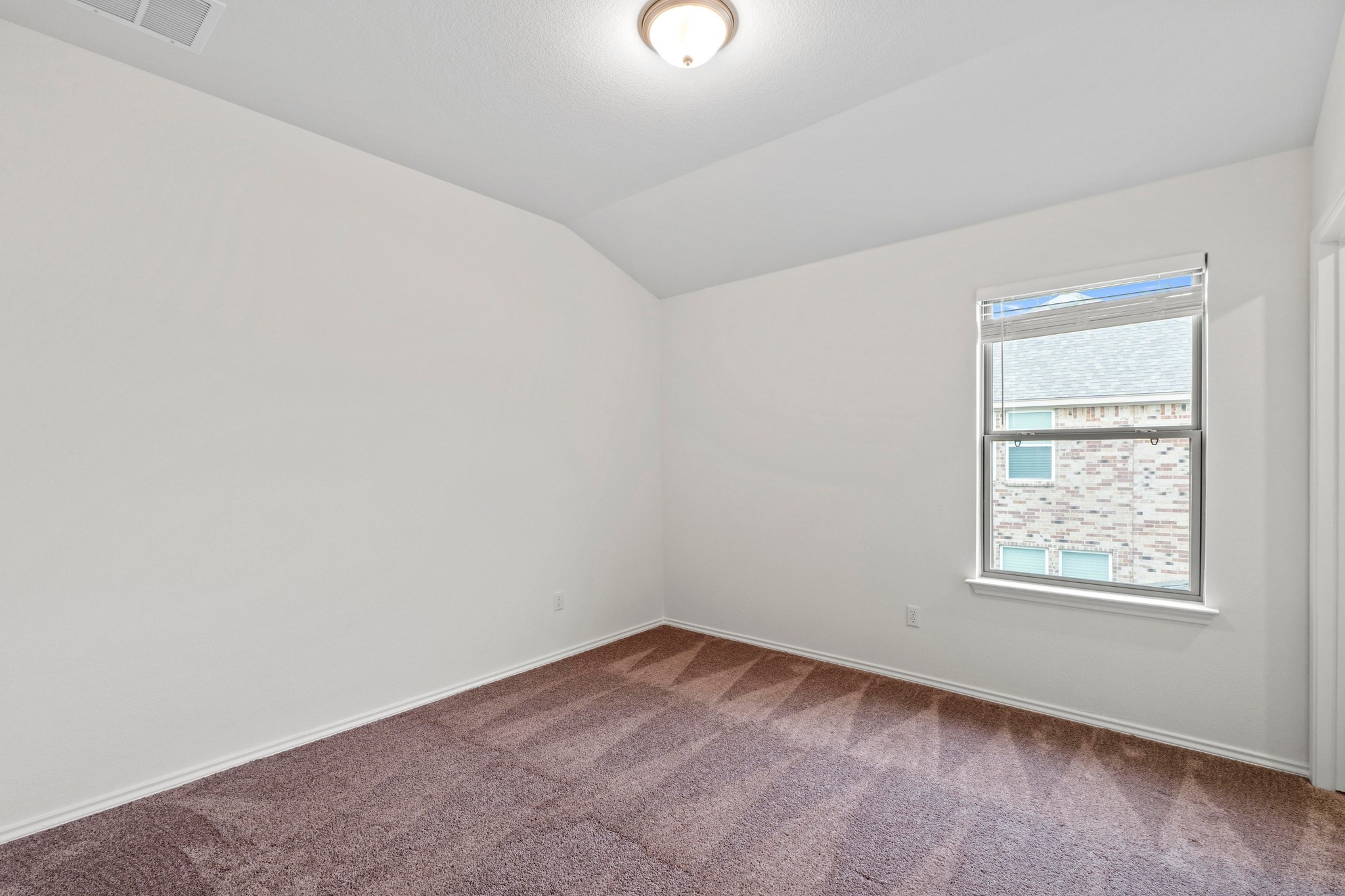 4729 San Rufo Drive Round Rock, TX 78665 - Photo 27 of 36 Bedroom featuring a vaulted ceiling, brown carpet, white baseboards, and a double-hung window with blinds