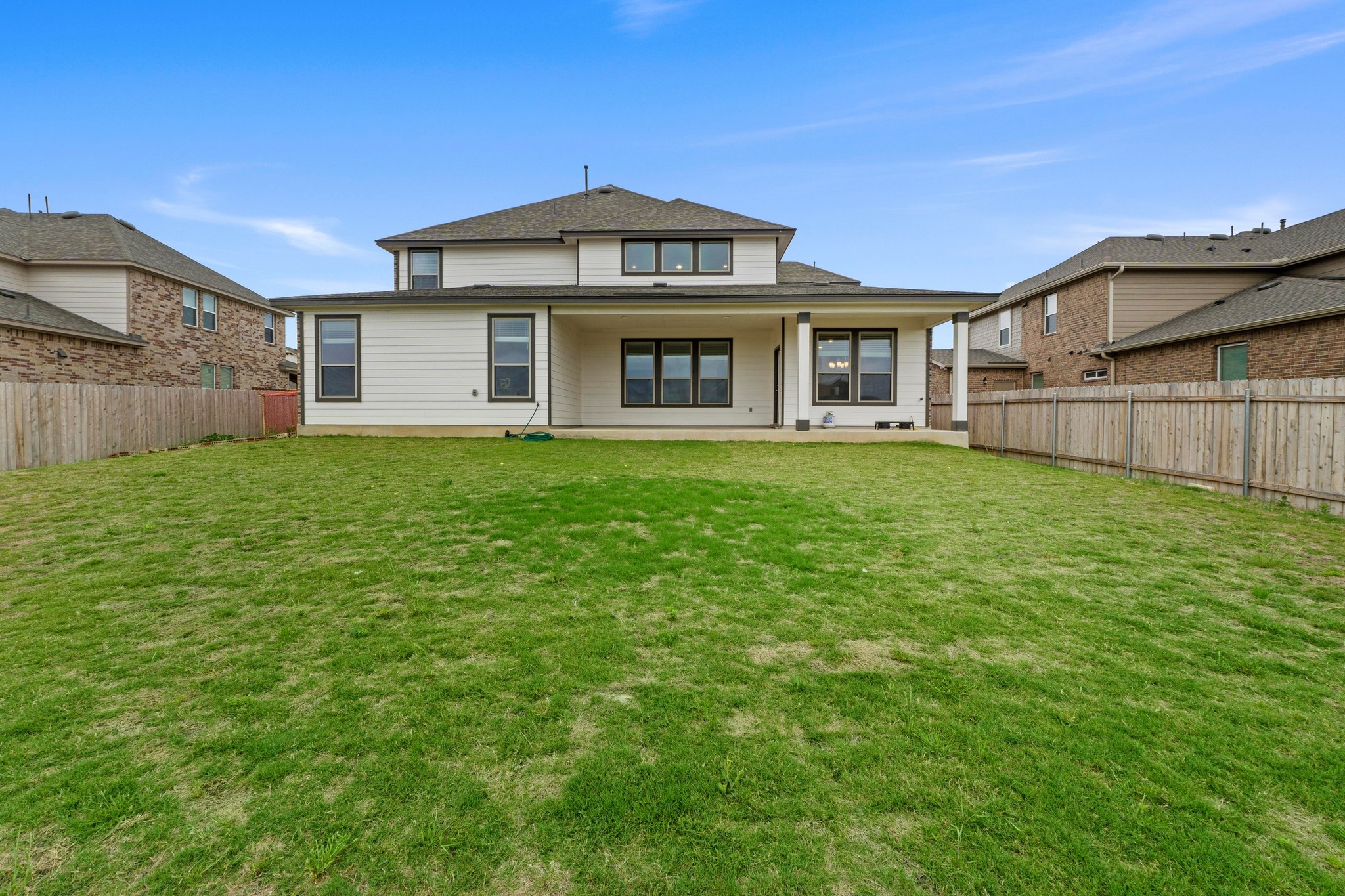 4729 San Rufo Drive Round Rock, TX 78665 - Photo 36 of 36 Expansive grassy yard featuring a covered patio, white siding, dark trim windows, and a privacy fence