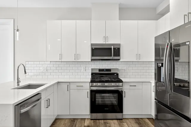 a kitchen with cabinets stainless steel appliances and a sink