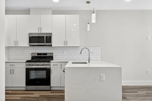 a kitchen with stainless steel appliances a stove a sink and a microwave