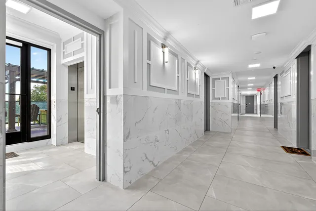 a view of a hallway with stainless steel appliances