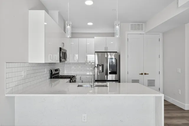 a kitchen with stainless steel appliances a sink and a refrigerator