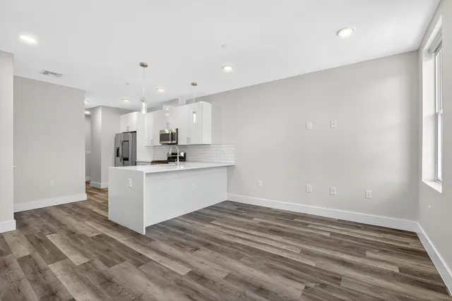 a view of kitchen with wooden floor and electronic appliances