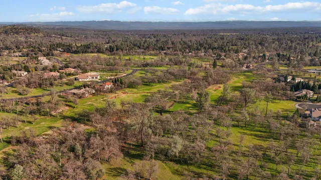 an aerial view of residential building with parking and yard