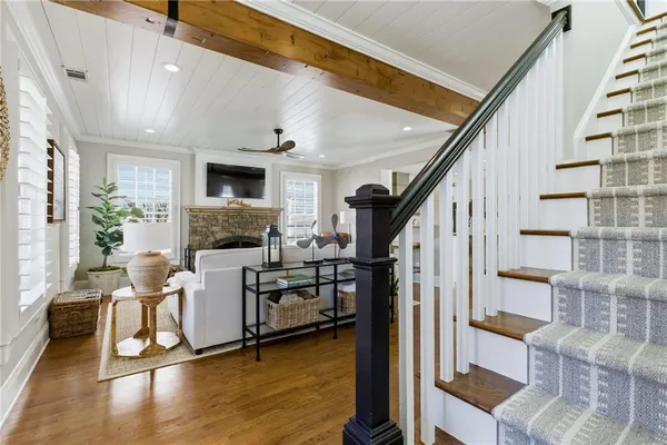a view of a hallway with wooden floor and windows