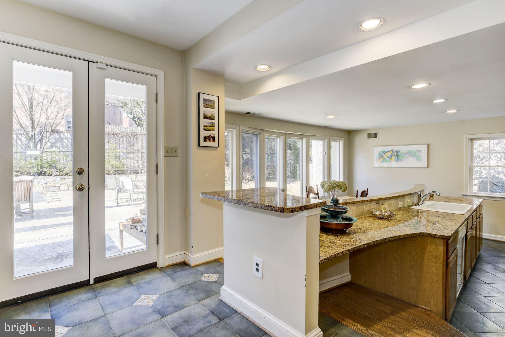 6800 Glenbrook Road Bethesda, MD 20814 - Photo 16 of 30 a view of a kitchen with kitchen island granite countertop wooden cabinets and white appliances