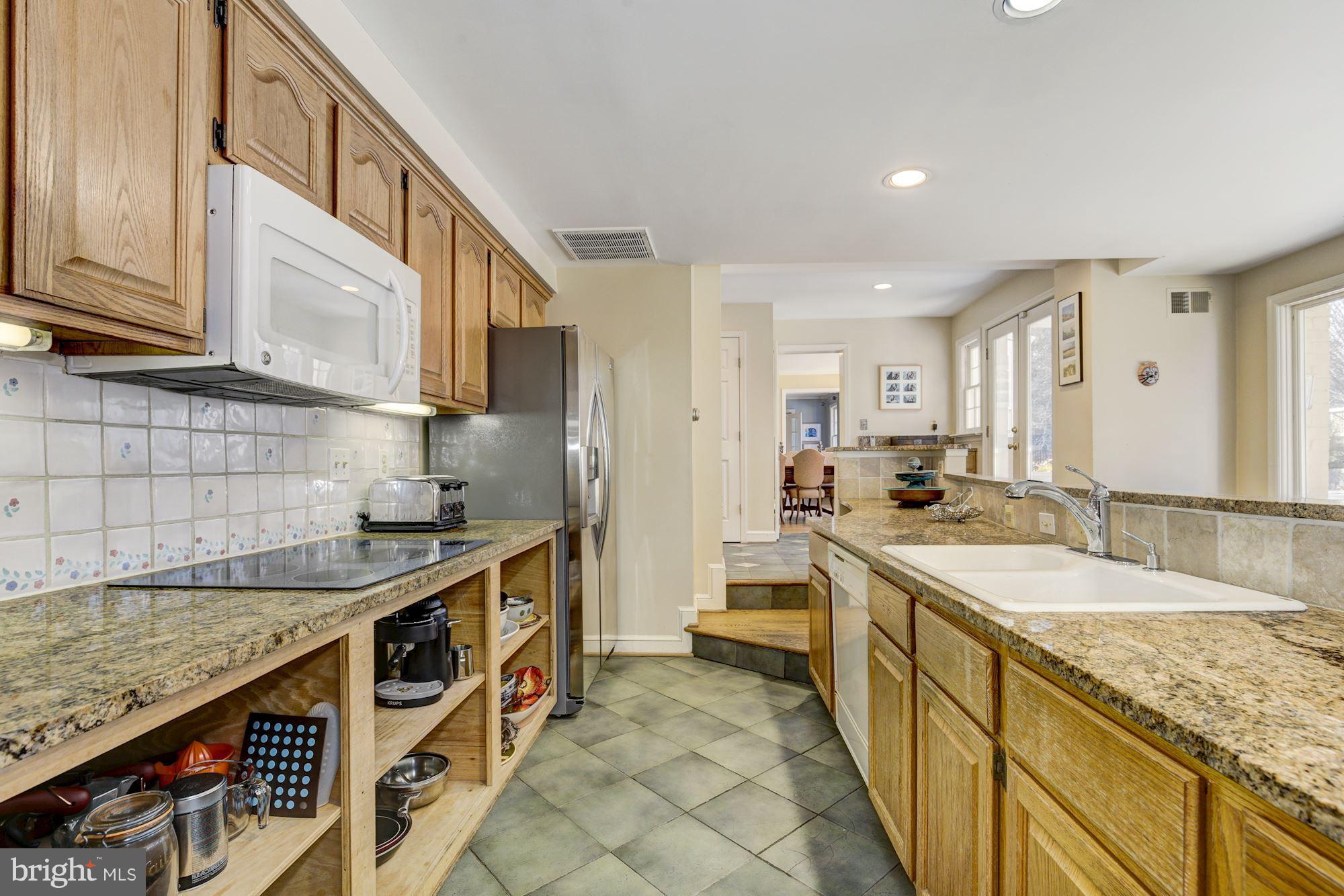 6800 Glenbrook Road Bethesda, MD 20814 - Photo 17 of 30 a kitchen with stainless steel appliances granite countertop a sink and cabinets