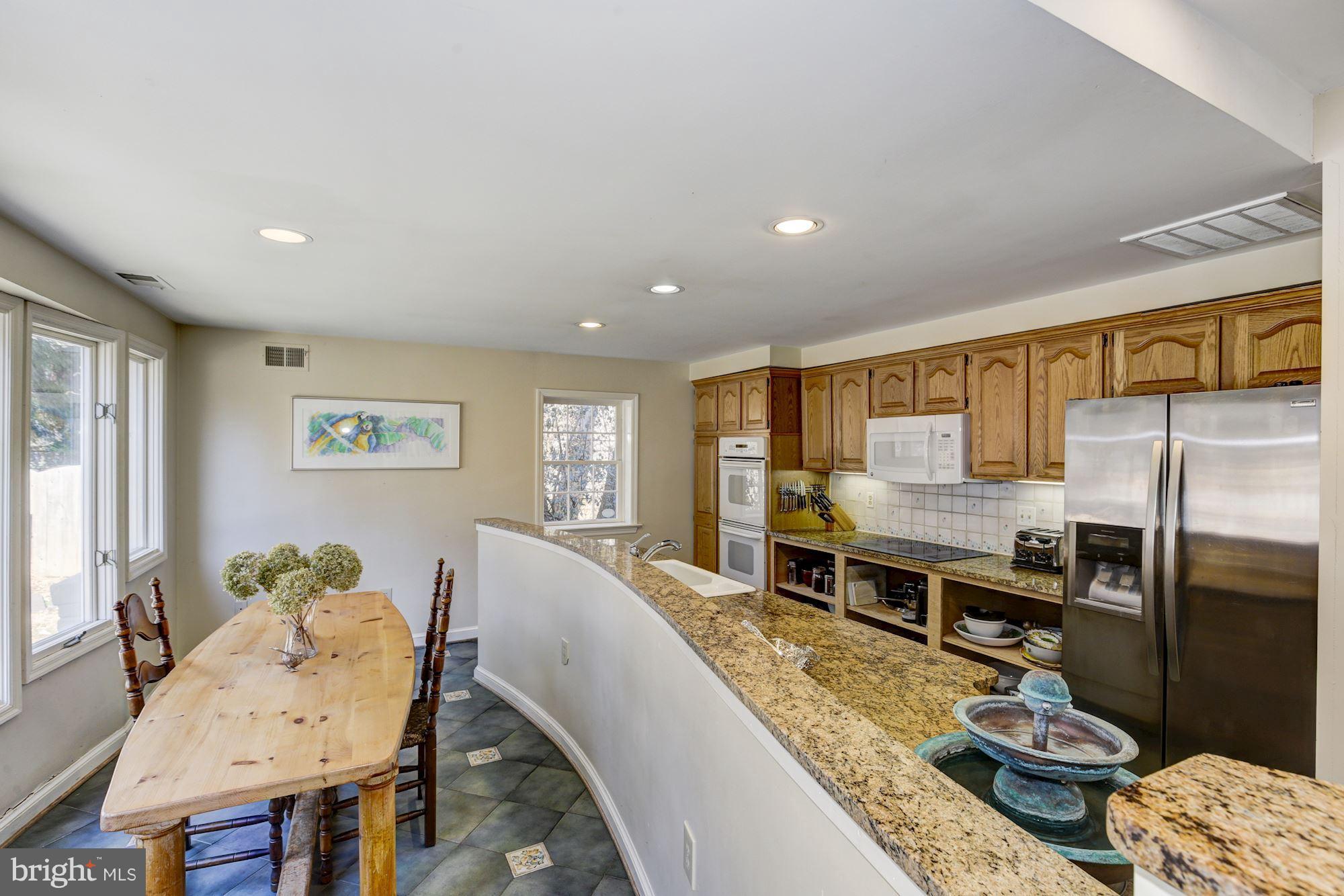6800 Glenbrook Road Bethesda, MD 20814 - Photo 18 of 30 a living room with stainless steel appliances furniture a rug and a table