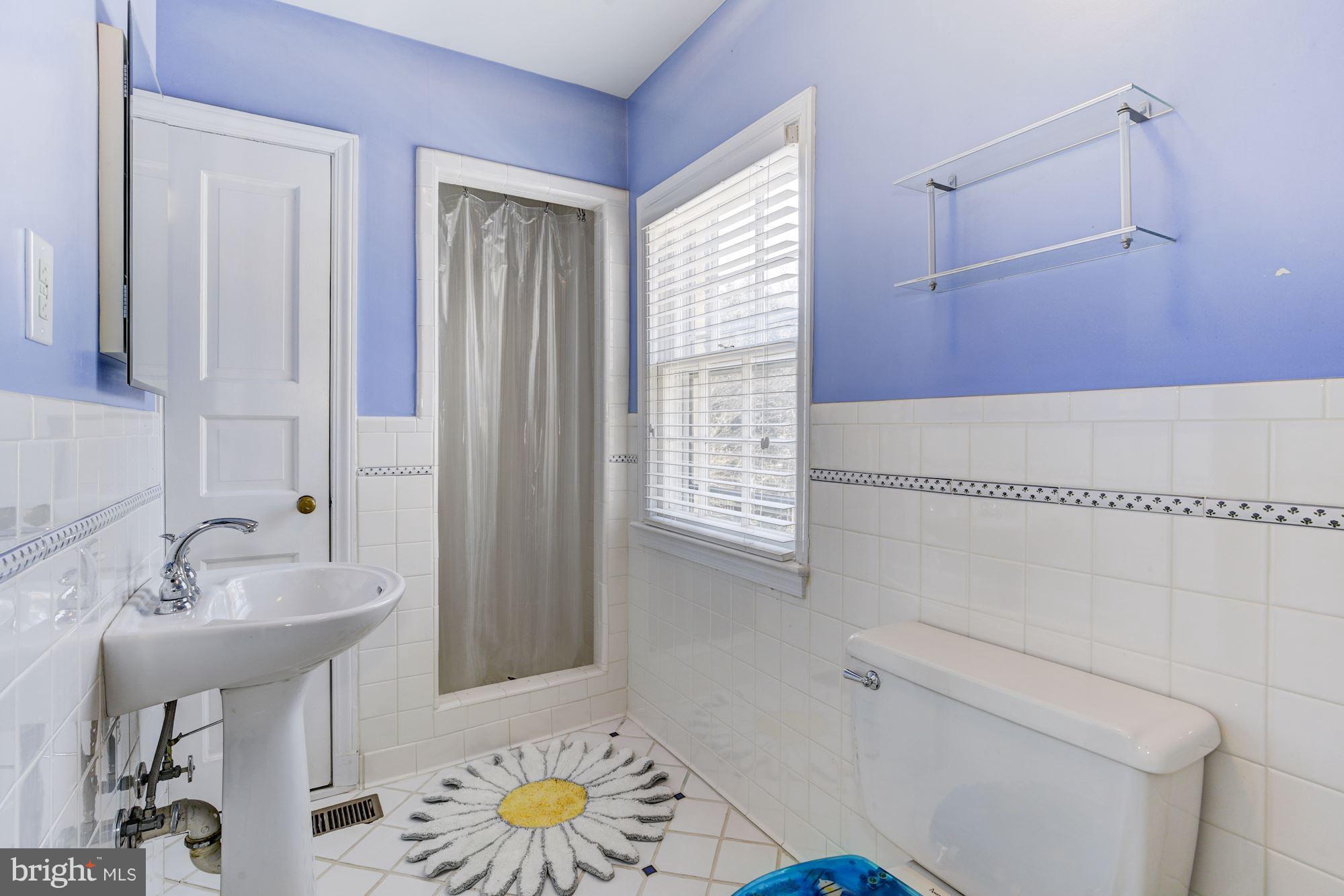 6800 Glenbrook Road Bethesda, MD 20814 - Photo 25 of 30 a bathroom with a sink a toilet and shower curtain