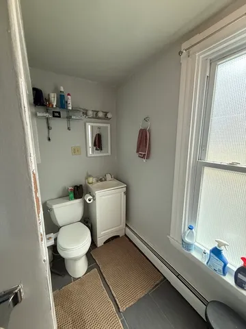 a bathroom with a toilet a sink and a window