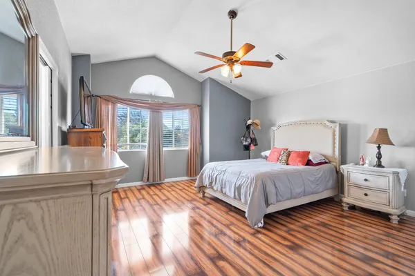 a bedroom with a bed and wooden floor
