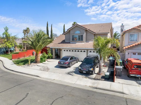 a view of a house with a patio and a yard