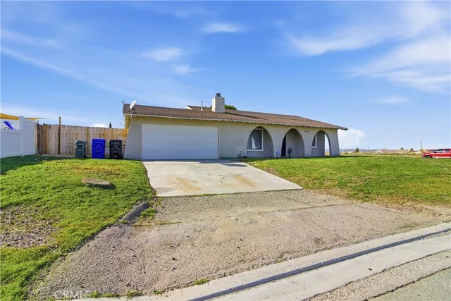a view of a house with a yard and potted plants
