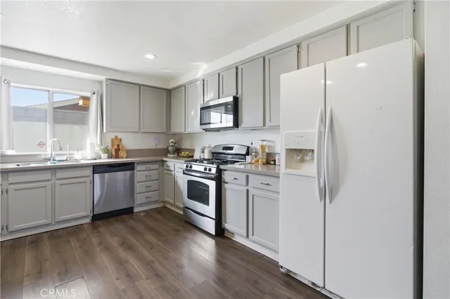 a kitchen with a refrigerator a sink and a stove top oven