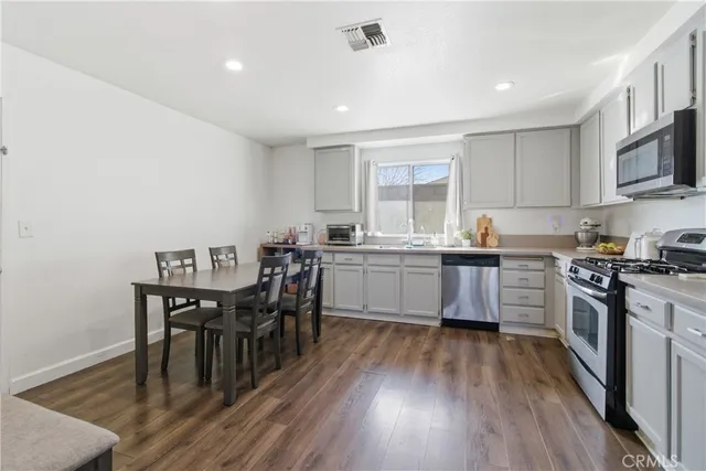 a kitchen with a table chairs microwave and cabinets