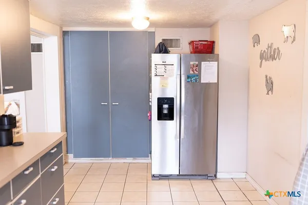 a kitchen with refrigerator and cabinets