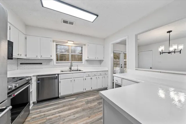 a view of a kitchen with wooden floor and a ceiling fan