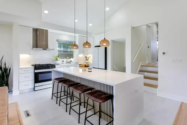 a kitchen with white cabinets and sink